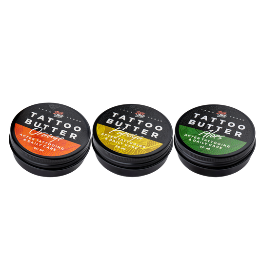 Tři balení Tattoo Butter 50 ml v hliníkových plechovkách - se žlutou etiketou Tattoo Butter Papaya, s oranžovou etiketou Tattoo Butter Orange a se zelenou etiketou Tattoo Butter Aloe.
