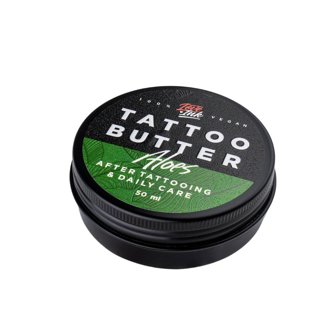 Balení Tattoo Butter Aloe 50 ml v hliníkové plechovce se zelenou etiketou na pozadí aloe vera