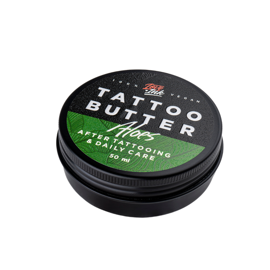 Balení Tattoo Butter Aloe 50 ml v hliníkové plechovce se zelenou etiketou na pozadí aloe vera