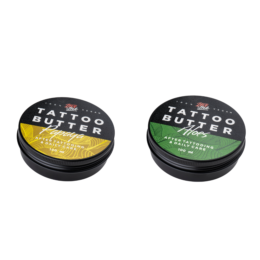 dvě balení Tattoo Butter Aloe v hliníkové plechovce se zelenou etiketou a Tattoo Butter Papaya se žlutou etiketou.